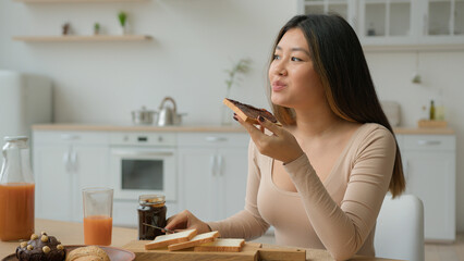 Asian korean woman eat sweet sandwich at home chinese girl female housewife cooking breakfast with...