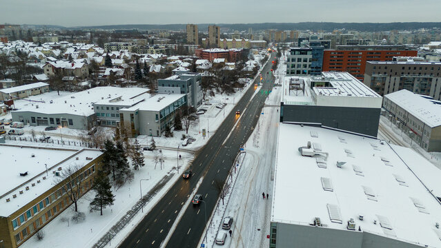 Drone photography of a city, street and buildings covered by snow during winter day