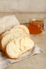 Bread with butter and jar of honey on white background