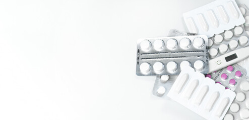 Medicines on a white background. Pills and a thermometer lie mixed up on a white background....