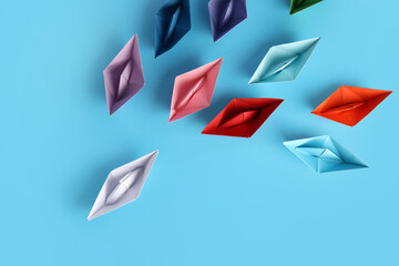 Colorful origami boats on color background