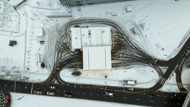 Drone photography of directly above petrol station and tire imprints during winter day