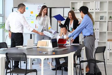 Mature businessman suffering from noisy colleagues in office