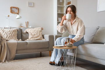 Young woman drinking hot tea at home