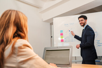 Male finance mentor coaching a business female, teaching a marketing strategy. Leader man talking...