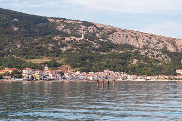 Fototapeta premium Scenic view of idyllic coastal town Baska, Krk Island, Primorje-Gorski Kotar, Croatia, Europe. Majestic coastline with high mountains and steep cliffs. Mediterranean Adriatic architecture of old town