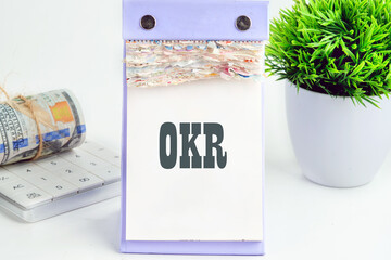 OKR text (Objectives, Key and Results) on a piece of a desktop calendar with tear-off pages