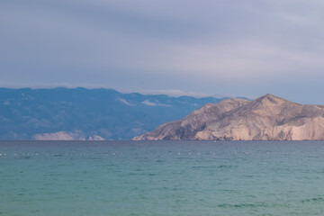 Scenic view of deserted island Prvic seen from beach in coastal town Baska, Krk Otok, Primorje-Gorski Kotar, Croatia, Europe. Majestic coastline of Mediterranean Adriatic Sea in Kvarner bay in summer