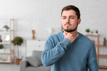 Young man with thyroid gland problem at home