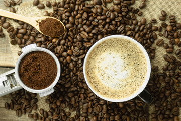 Coffee beans scattered on the table. Close-up of coffee beans and ground coffee. Copy space