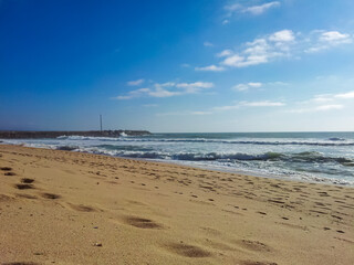 Panoramic view of paradise golden sand beach of coastal village Ericeira, Portugal, Europe. Looking at majestic Atlantic Ocean. Serene tranquil vacation atmosphere. Empty tropical landscape in summer