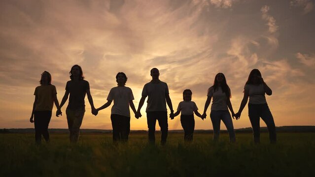 community big family in the park. large group sunset of lifestyle people holding hands walking silhouette nature in the park. big family childhood dream concept. people in the park. big family
