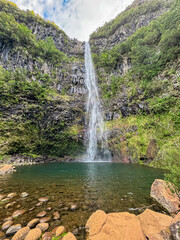 Scenic view of majestic waterfall Cascata Risco along idyllic Levada walk 25 fountains in evergreen subtropical Laurissilva forest of Rabacal, Madeira island, Portugal, Europe. Plunge pool below