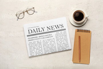 Newspaper with cup of coffee and glasses on white background. Top view