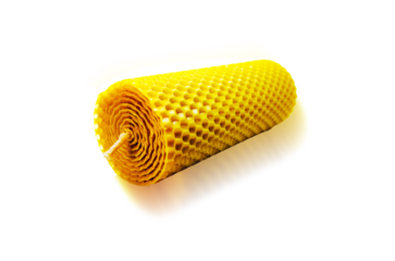 A natural wax-colored candle lies Isolated on white background with a shadow Copy space Honeycomb Octagon Wax candle