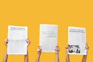 Fototapeta na wymiar Women with newspapers on yellow background