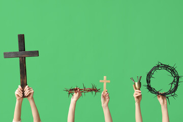 Female hands with crowns of thorns, crosses and nails on green background. Good Friday concept