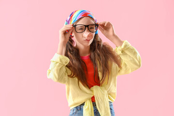 Funny little girl in disguise on pink background. April Fools' Day celebration