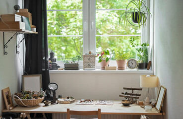 Interior of cozy room with wooden office desk near window with green plant. Nobody.
