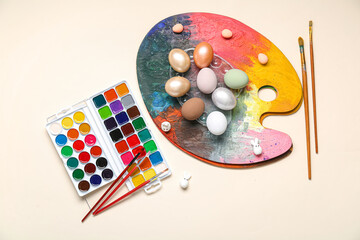 Paint palette with Easter eggs on white background. Easter concept.