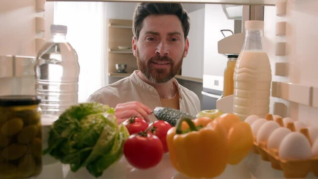 Point of view POV inside refrigerator Caucasian man husband guy male homeowner chef open fridge full of healthy fresh vegetables take out tomato pepper eggs for cooking salad at kitchen food delivery
