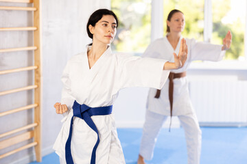 Women in kimonos are focusing on their hand punch training, refining their striking techniques.