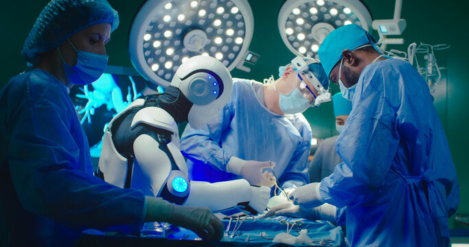 Professional surgeon together with robot sutures patient in operating room . Group of medical workers wearing special uniforms, gloves and masks performs operation with help of modern equipment. - Powered by Adobe