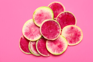 Slices of ripe watermelon radish on pink background
