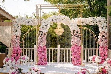 Outdoor wedding photo zone decorated with flowers.