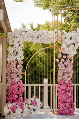 Outdoor wedding photo zone decorated with flowers.