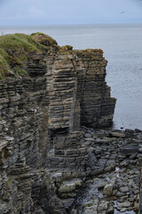 Fototapeta na wymiar Rugged Scottish coastline with magnificent layered cliffs rising above ocean