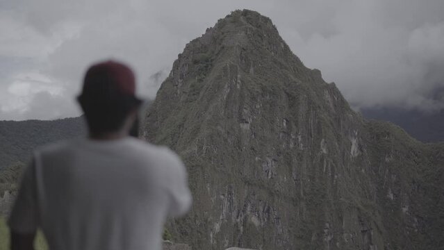 Una persona observando el Huayna Picchu en Machu Picchu, Cusco. La escena est&aacute; representada en c&aacute;mara lenta, con un estilo visual de color plano y utilizando la t&eacute;cnica Slog 2 en una resoluci&oacute;n de 4k.