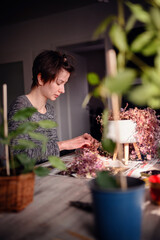 A moment of introspection and care, a woman delicately handles small plants, fully immersed in the...