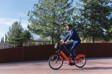 Side view of businessman riding an electric bike. Sustainable business and lifestyle. Copy space.