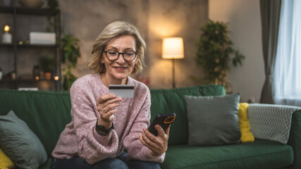 mature woman caucasian female hold credit card online shopping at home