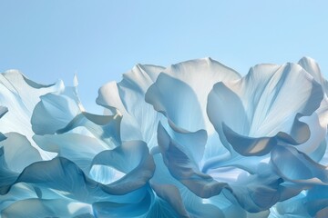 An artistic composition of light and shadow playing across the soft, undulating petals of flowers in shades of blue, suggesting movement and lightness