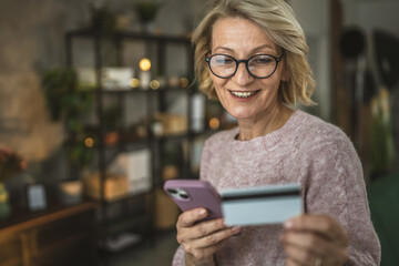 mature woman caucasian female hold credit card online shopping at home