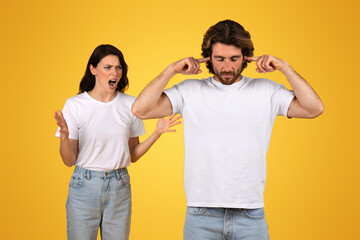 Annoyed woman yelling with hands open in disbelief while man beside her plugs his ears