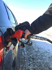 Filling up the vehicle with gasoline at a gas station