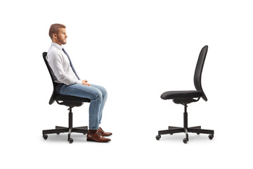 Profile shot of a businessman sitting in an office chair opposite an empty chair