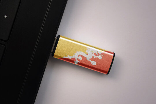 usb flash drive in notebook computer with the national flag of bhutan on gray background. - Powered by Adobe