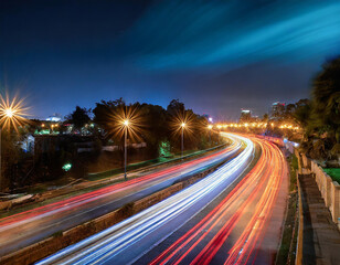 Fototapeta na wymiar Long exposure captures dynamic light trails along city roads at night