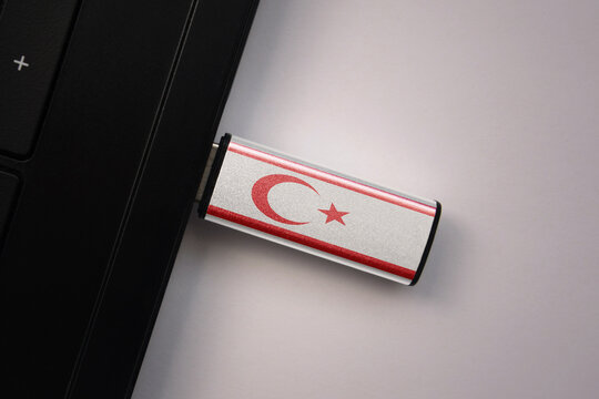 usb flash drive in notebook computer with the national flag of northern cyprus on gray background.