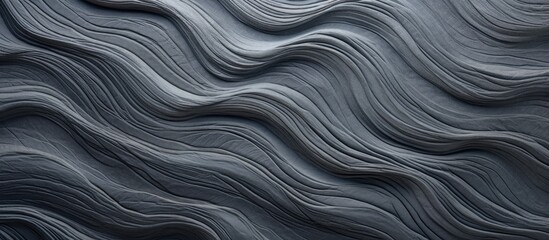 A close up of a swirling grey marble pattern, resembling waves in a dark landscape. The texture is reminiscent of rock or metal, with hints of electric blue and brown tones