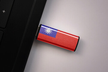 usb flash drive in notebook computer with the national flag of taiwan on gray background.