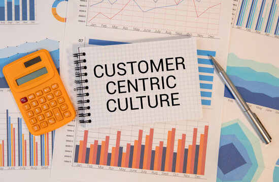 Text CUSTOMER CENTRICITY on white paper on clipboard with chart and calculator