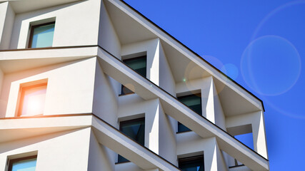 View of a white modern apartment building. Perfect symmetry with blue sky. Geometric architecture detail modern concrete structure building. Abstract concrete architecture. 