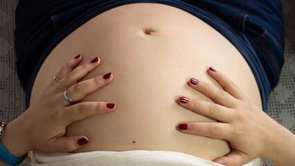hands caress belly of pregnant woman