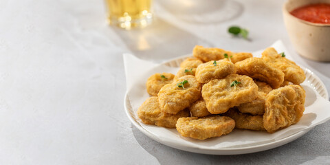There is a plate of crispy chicken nuggets on the table. Fast food, fast food restaurant. Copy space