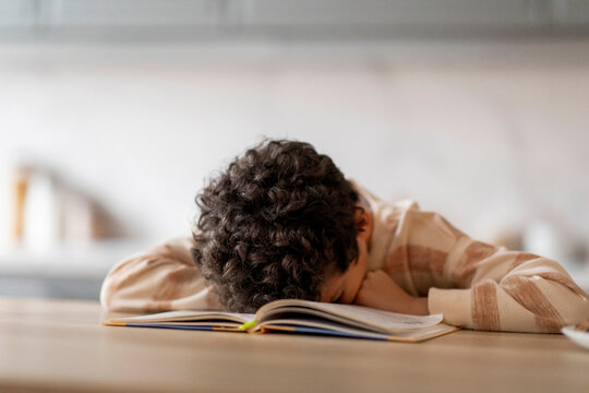Exhausted Black Boy Sleeping On Books While Doing School Homework